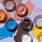 Colorful makeup swatches on a textured surface