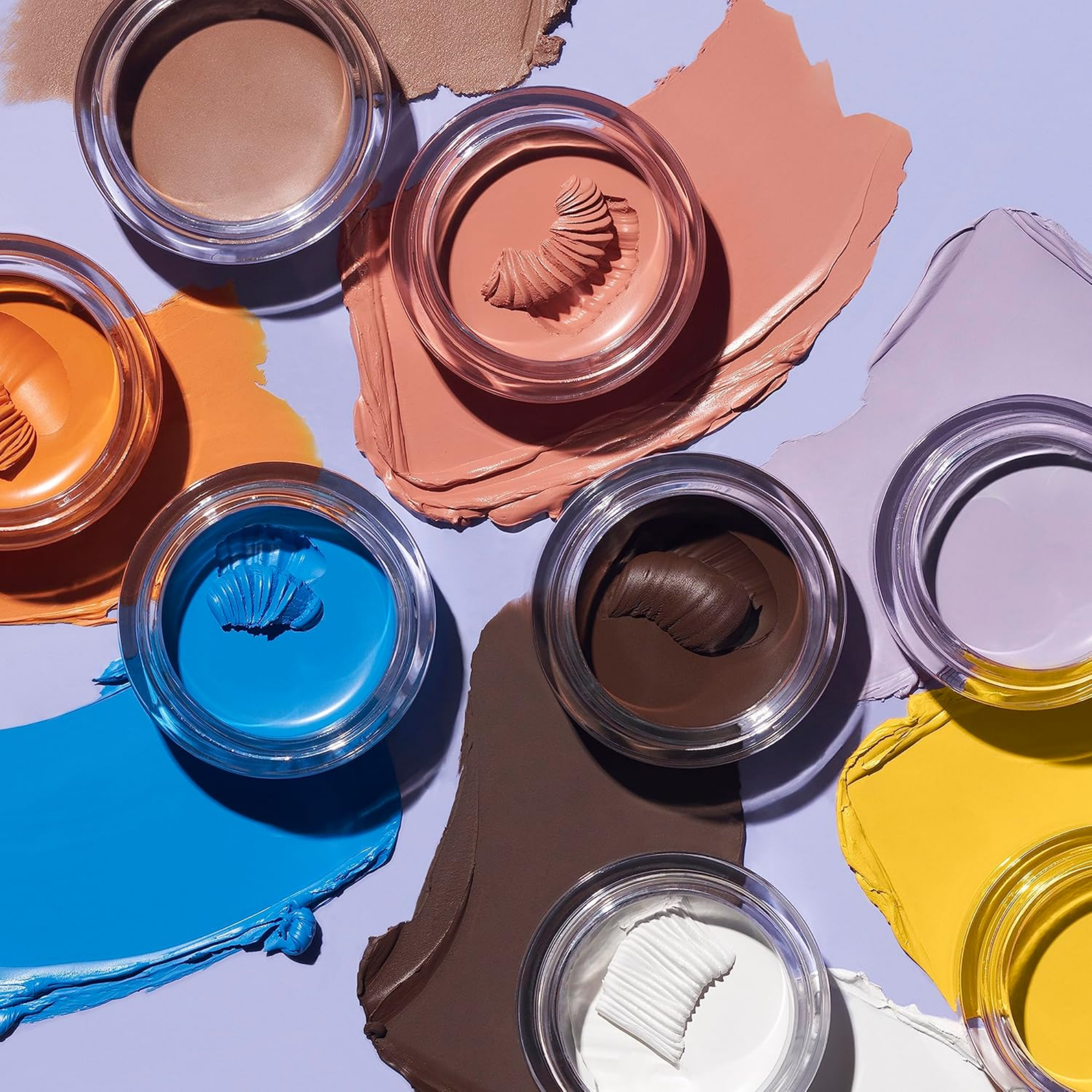 Colorful makeup swatches on a textured surface