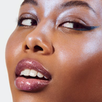 Model draagt e.l.f. Prismatic Lip Gloss Amethyst voor glanzende, volumineus ogende lippen.