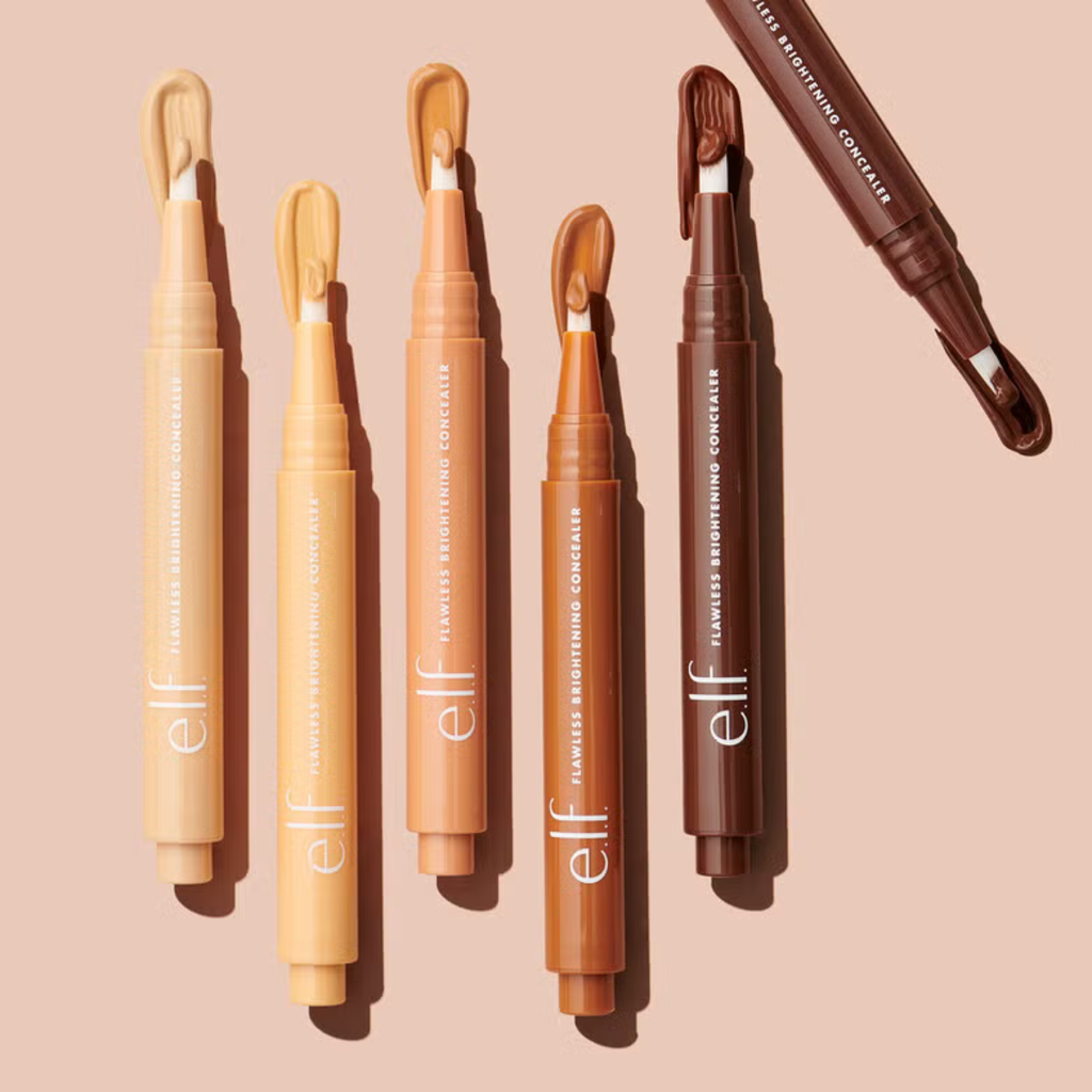 Set of e.l.f. brand concealer pens on a beige background
