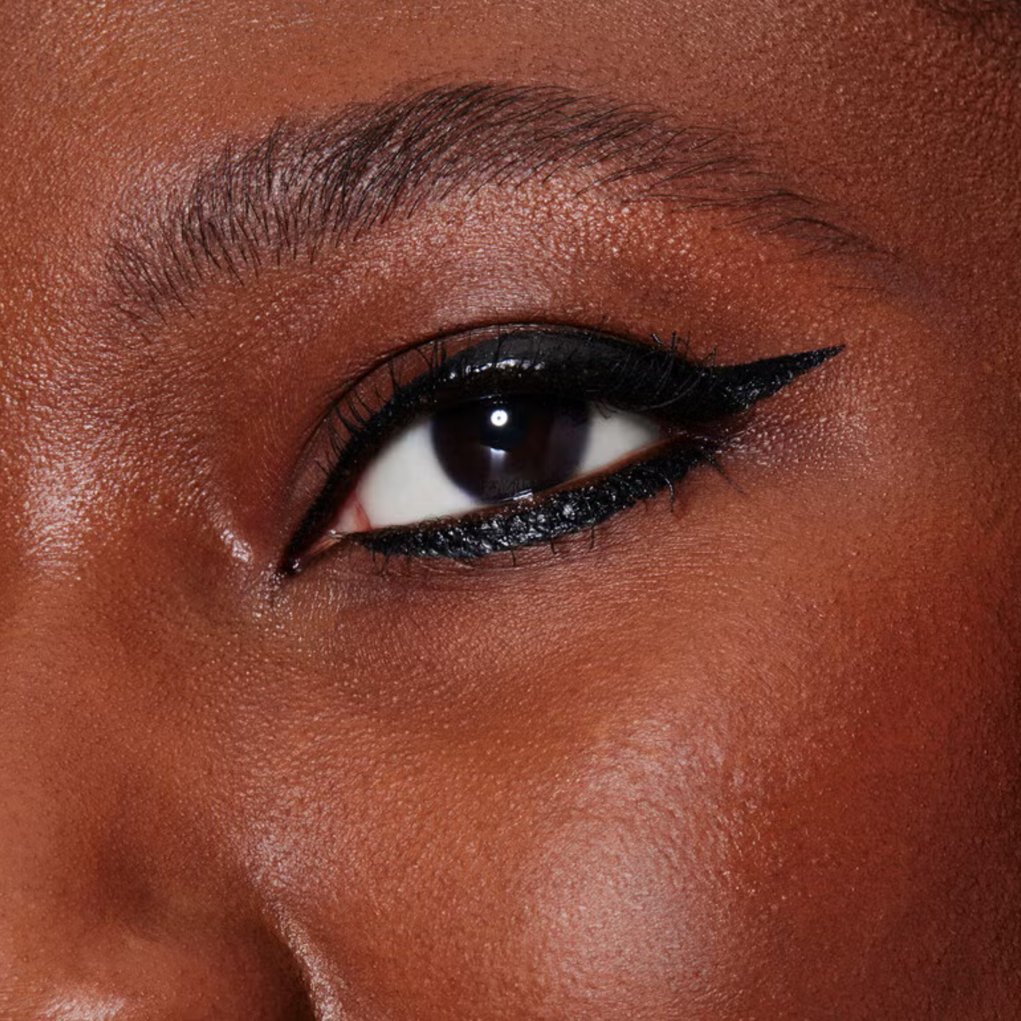 Close-up of a person's eye with dark eyeliner on brown skin