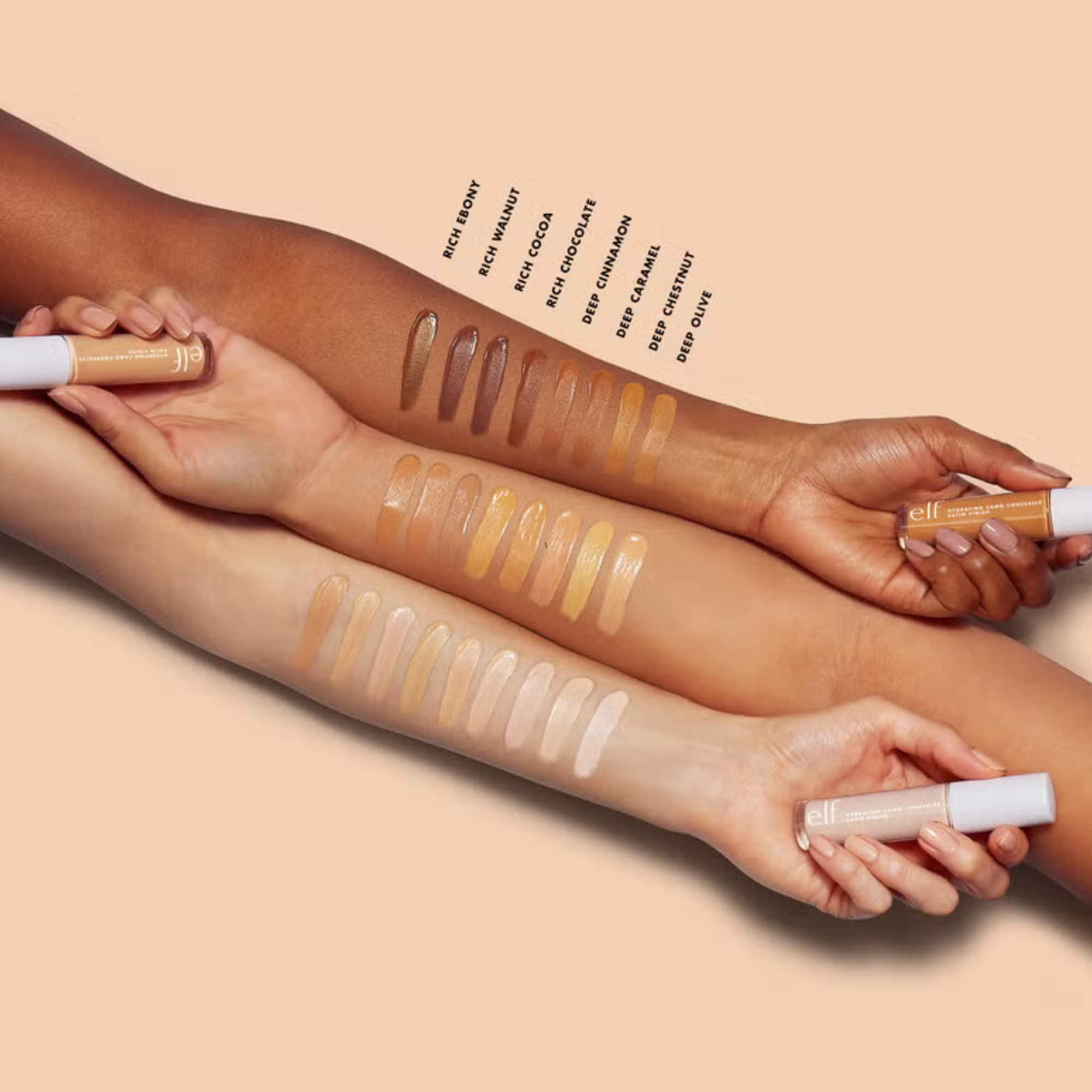 Hands holding makeup products with color swatches on a beige background