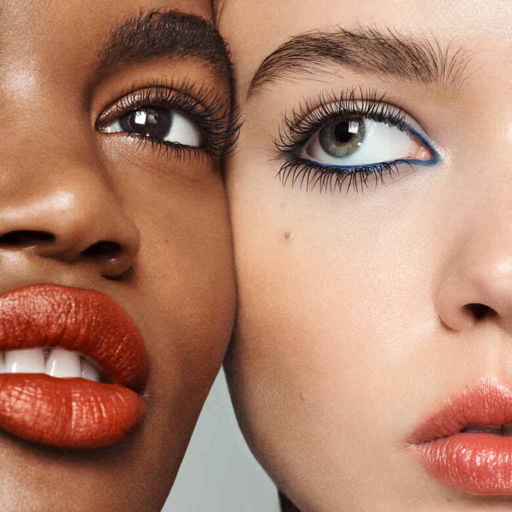 Close-up of two faces with different skin tones and eye colors wearing the same lash it loud mascara