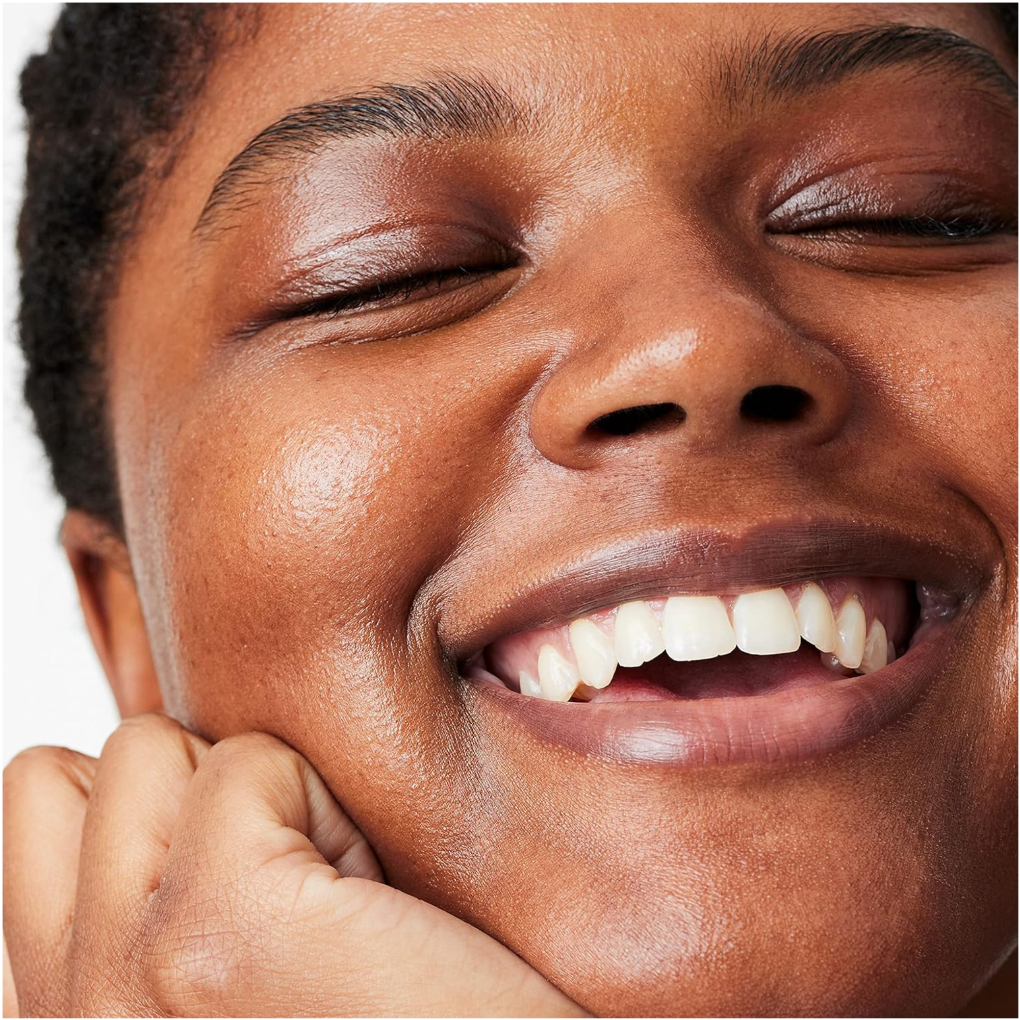 Close-up of a person with a joyful expression, eyes closed, on a white background