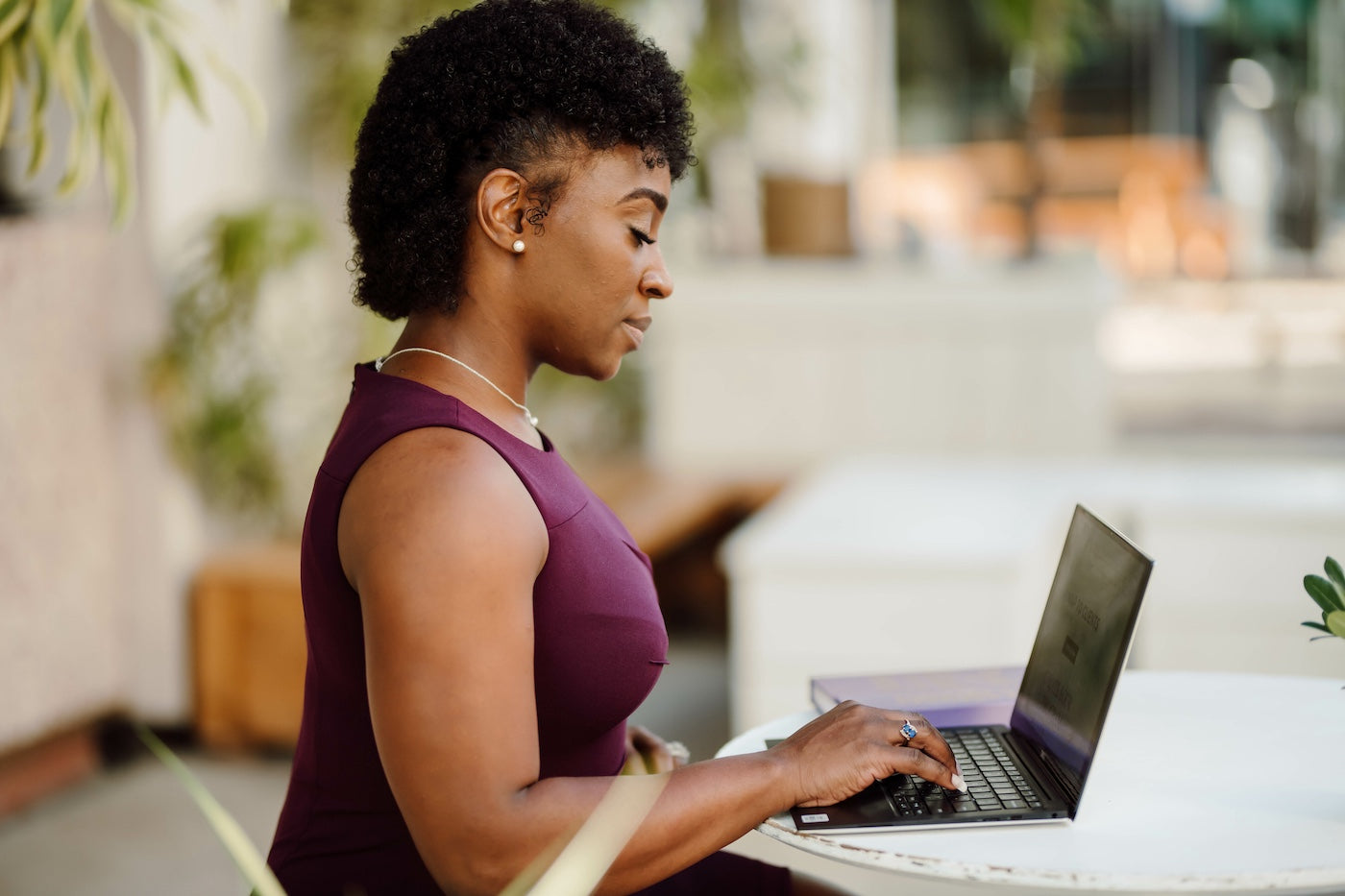 Woman working on a laptop, representing independence and access to work supported by She Matters