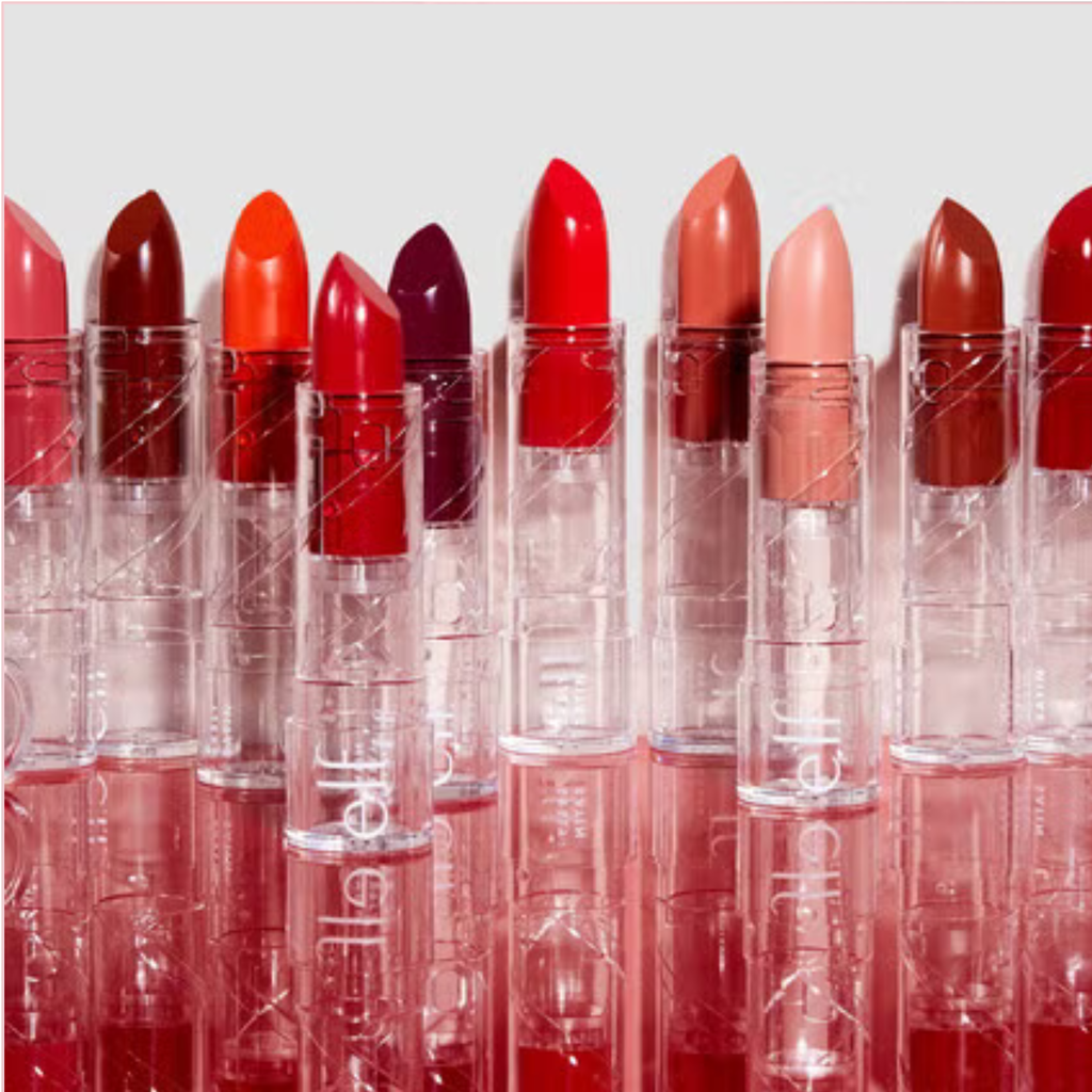 Row of lipsticks in various colors with clear casings on a light gray background